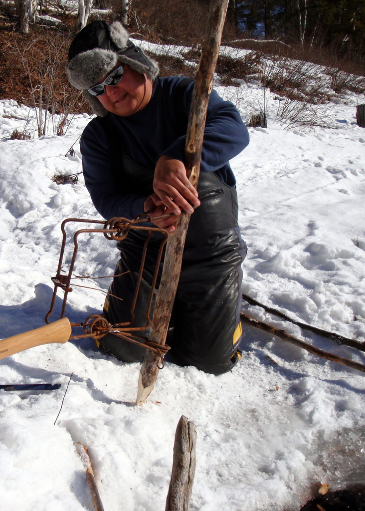 First Nations trapper setting a conibear trap (photo credit: Crystal Luxmore, used under CC BY-NC 2.0)
